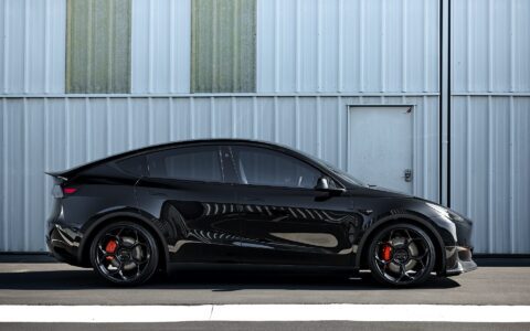 Side angle of a Tesla Model Y featuring Unplugged Performance's UP-05 wheels and carbon fiber front lip spoiler, highlighting the vehicle's enhanced stance and upgraded aerodynamics.