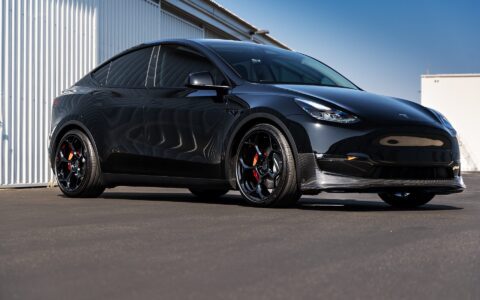 Tesla Model Y outfitted with Unplugged Performance carbon fiber front lip spoiler and UP-05 wheels, emphasizing the aesthetic and performance upgrade in a 3/4 pose.