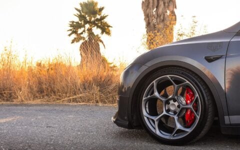 Side profile of Tesla Model Y with Unplugged Performance UP-05 wheels, front carbon fiber lip spoiler, and performance coilovers for a lowered, aggressive stance.