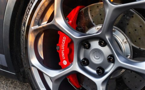 Detailed shot of Unplugged Performance UP-05 wheels and red big brake kit, emphasizing the performance upgrades and precision engineering for Tesla Model Y.
